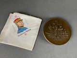 the coin is next to a small pouch with a picture of a man on it
