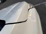 a close up of a car ' s hood with a dent in it
