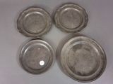 quatre assiettes plaquées argent sur un fond blanc orné d'un point blanc