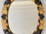 an ornate gold and black mirror hanging on a wall