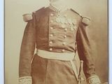 une vieille photo d'un homme en uniforme militaire debout devant une table