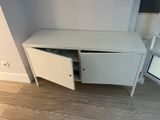 a white cabinet with a door open on a wooden floor
