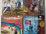 a set of four comic books on a white surface