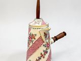 une petite théière avec une anse en bois sur fond blanc