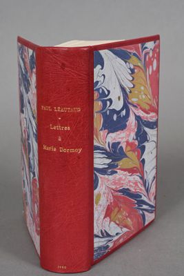 an old book with a red cover and a floral design