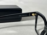sunglasses with black frames and gold accents are laying on a white surface
