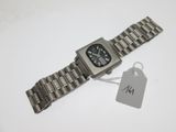une montre en argent, munie d'une étiquette, posée sur une table
