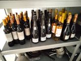 many bottles of wine sitting on a shelf in a kitchen