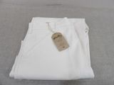 the white pants are stacked on top of each other on the bed