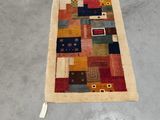 un grand tapis multicolore posé à même le sol dans une pièce