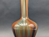 a vase that is sitting on a table in front of a gray background