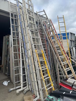 a pile of ladders that are outside of a building