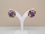 pair of multicolored crystal earrings on a white stand