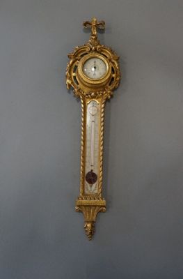 a gold clock hanging on the wall in a room
