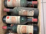 plusieurs bouteilles de vin dans une caisse en bois posée par terre
