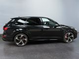 a black audi suv parked in a showroom with a white wall