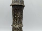 a large metal vase that is sitting on a table