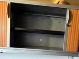 a metal cabinet with a door and shelves in the kitchen