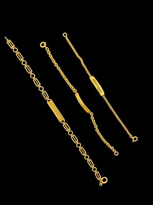 un lot de trois bracelets à chaîne dorés