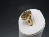 une bague en or posée sur une boîte blanche