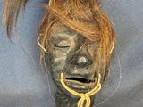 an image of a mask with hair tied to it ' s head