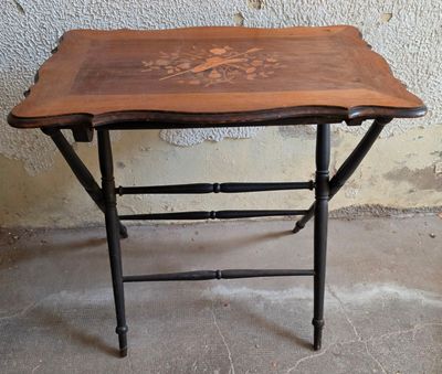 une petite table avec un plateau en bois sur un sol en ciment