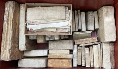 une boîte remplie de vieux livres posée sur un canapé