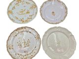 quatre assiettes ornées de motifs dorés et blancs sur un fond blanc