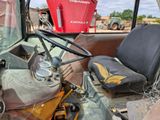 a tractor that is sitting in the dirt with a bucket