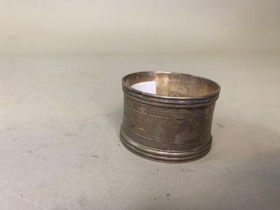 un porte-serviettes ancien plaqué argent posé sur une surface blanche