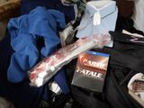 a pile of clothing and a dvd on a bed