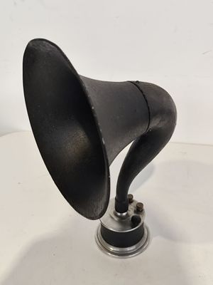 un vieux gramophone noir posé sur une table blanche