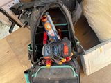 a backpack that is sitting on the floor next to a bed