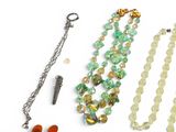 a necklace, bracelet, and other jewelry on a white surface