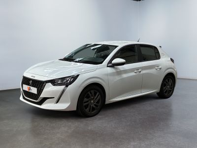 La voiture blanche est garée dans une pièce blanche au sol noir.