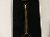 a green jade shaving in a box with a gold handle