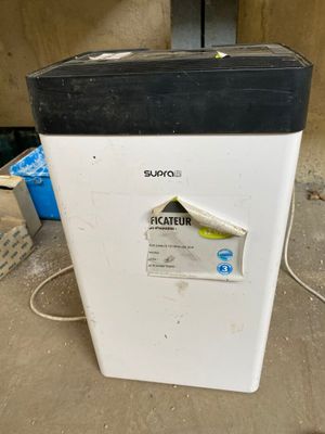 a white refrigerator with a black top sitting on the floor