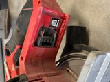 a picture of a red and black corded sander in a garage