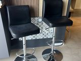 two black leather bar stools in a kitchen