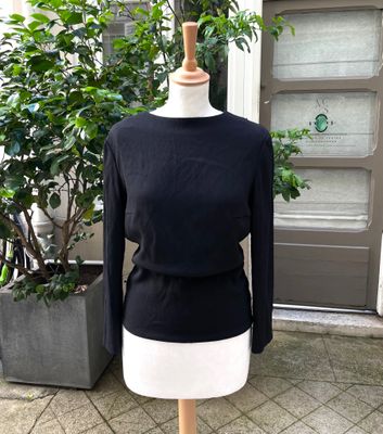 black and white sweater on a mannequin stand in front of a door
