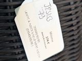 a black basket with a tag attached to it