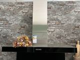 une photo d'une cuisine avec une cuisinière et un mur en briques