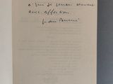 un livre ouvert, sur lequel repose une lettre manuscrite, posé sur une table