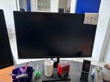 a desk with a computer monitor and a cell phone on it