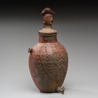 un vase marron surmonté d'un oiseau