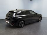 the rear end of a black car parked in a garage
