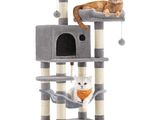 Deux chats sont assis au sommet d'un arbre à chat, au sommet duquel est suspendue une balle.