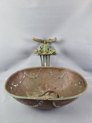 a brown bowl with a bird on top of it
