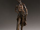 an image of a bronze statue of a man holding a staff