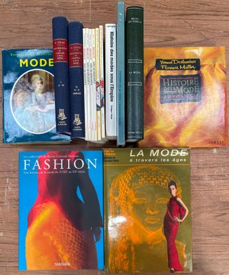 plusieurs livres posés sur une table en bois, avec une femme en robe rouge devant eux